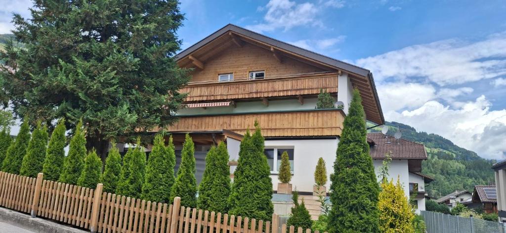 a wooden house with a fence and trees at Apart Ritzl in Fügen