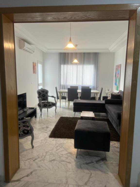 a living room with a couch and a table at Appartement meublé in Sukrah