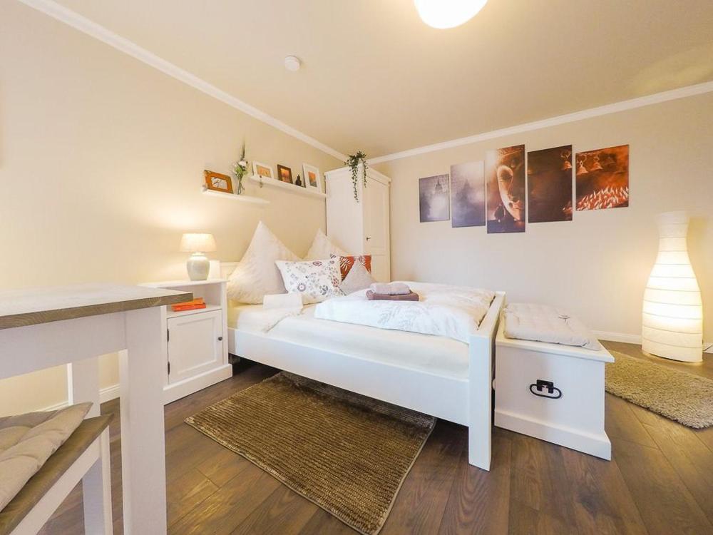 a bedroom with a white bed and a desk at Friendly Home Doppel-Doppelappartement Union in Bornheim