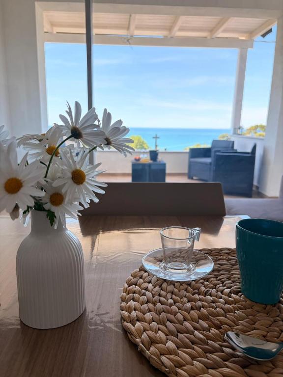 a table with a vase of flowers on a table at Circe Casa Vacanze in San Menaio