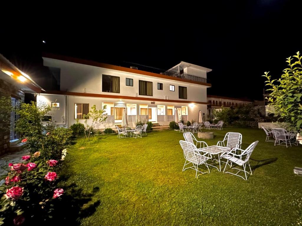 a yard with chairs and a house at night at Prestige by Alnoor in Skardu