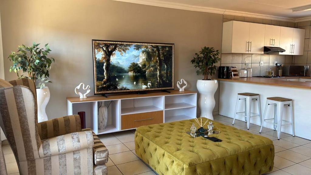 a living room with a couch and a kitchen at The Pebbles-Unit-1 in Mahikeng