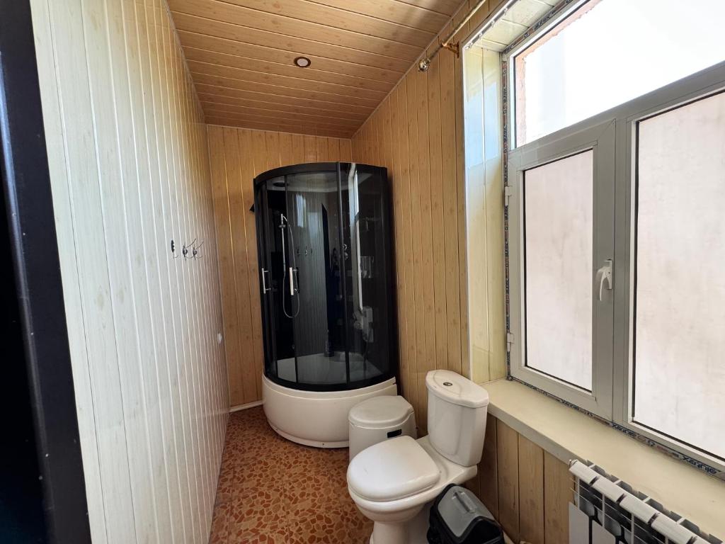 a bathroom with a toilet and a large window at Yangi Andijan Hotel in Andijan