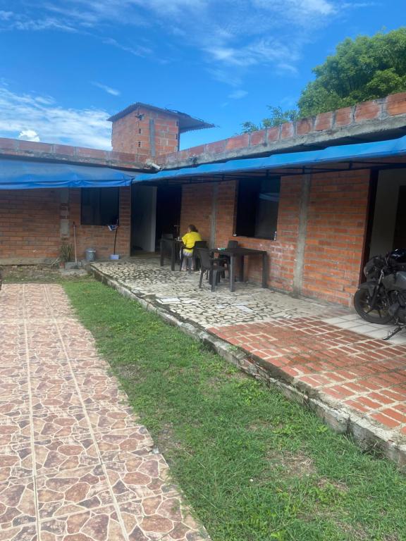 a person sitting at a table outside of a brick building at Santa Fe hostal in Santa Fe de Antioquia