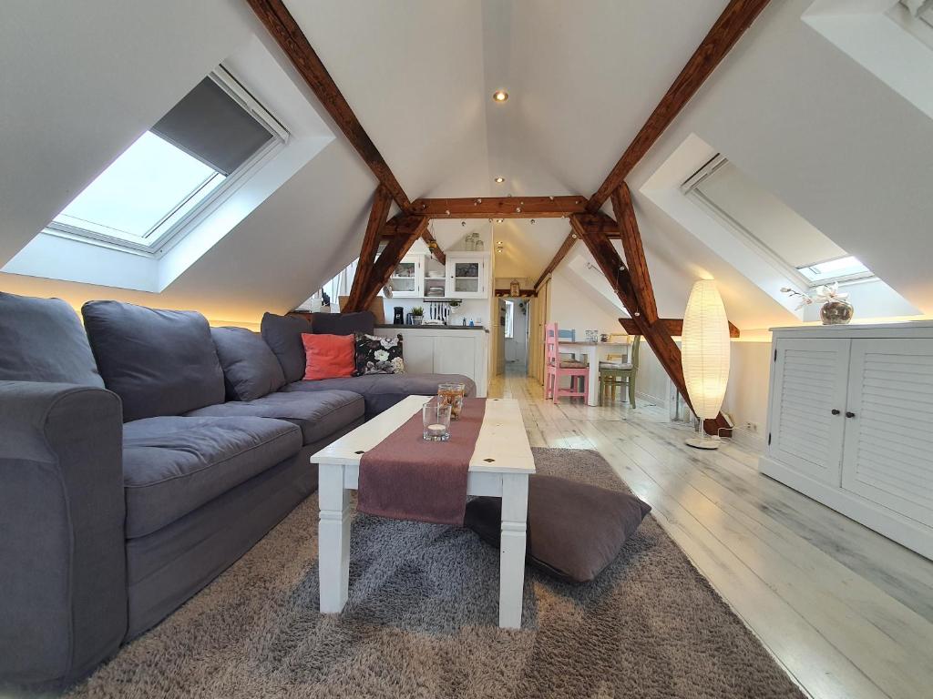 a living room with a couch and a table at Friendly Home - "Helles Dachstudio" Köln Bonn Phantasialand in Bornheim