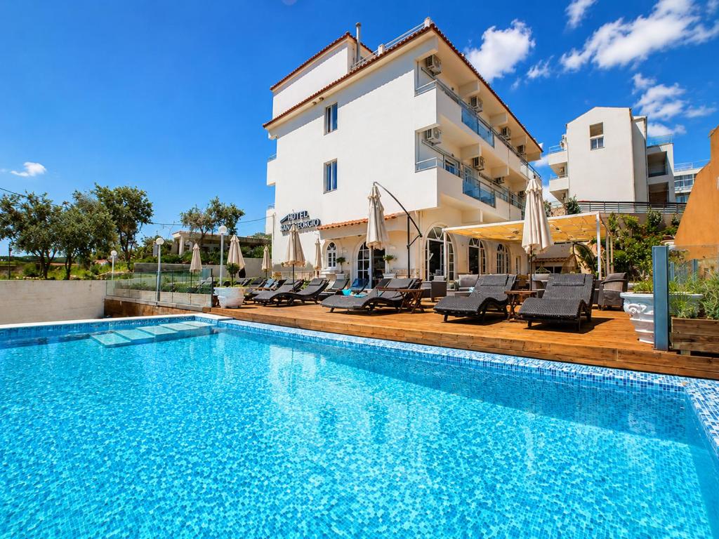a villa with a swimming pool and a building at San Georgio Hotel in Agios Georgios Pagon