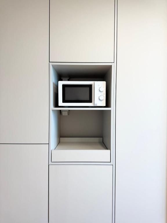 a microwave oven sitting inside of a cabinet at Yangyang Surfing Beach 19 in Saetchak