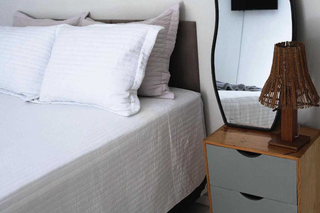 a bedroom with a bed with a mirror on a night stand at Suite Areal in Atins