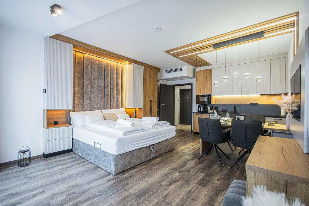 a bedroom with a bed and a kitchen and a table at ELYX Home Apartmanok in Sárvár