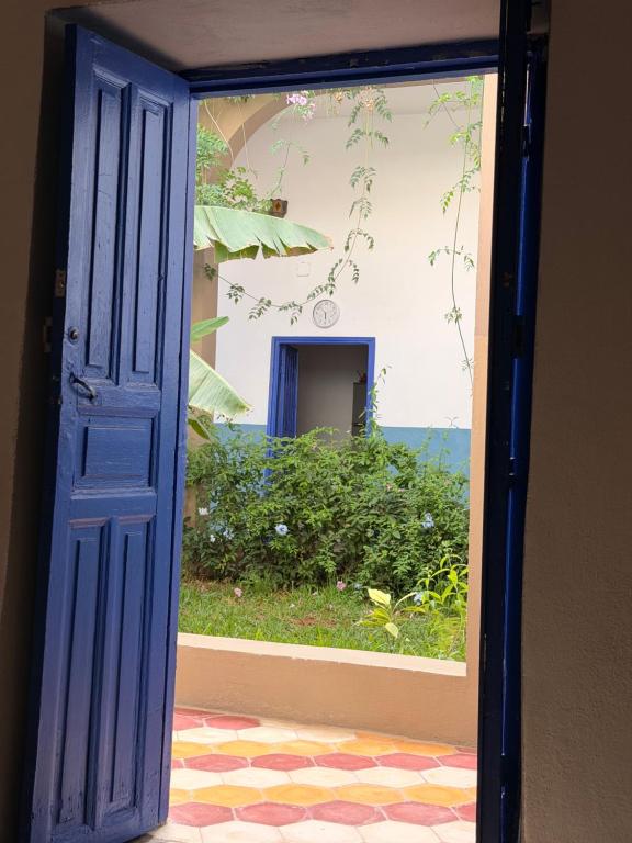 an open blue door with a view of a yard at RiadTiznitSouss Votre oasis privée à Tiznit in Tiznit