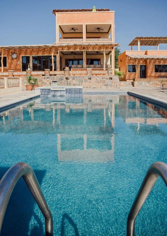 a swimming pool in front of a house at Casa San Jerónimo Departamentos in Todos Santos
