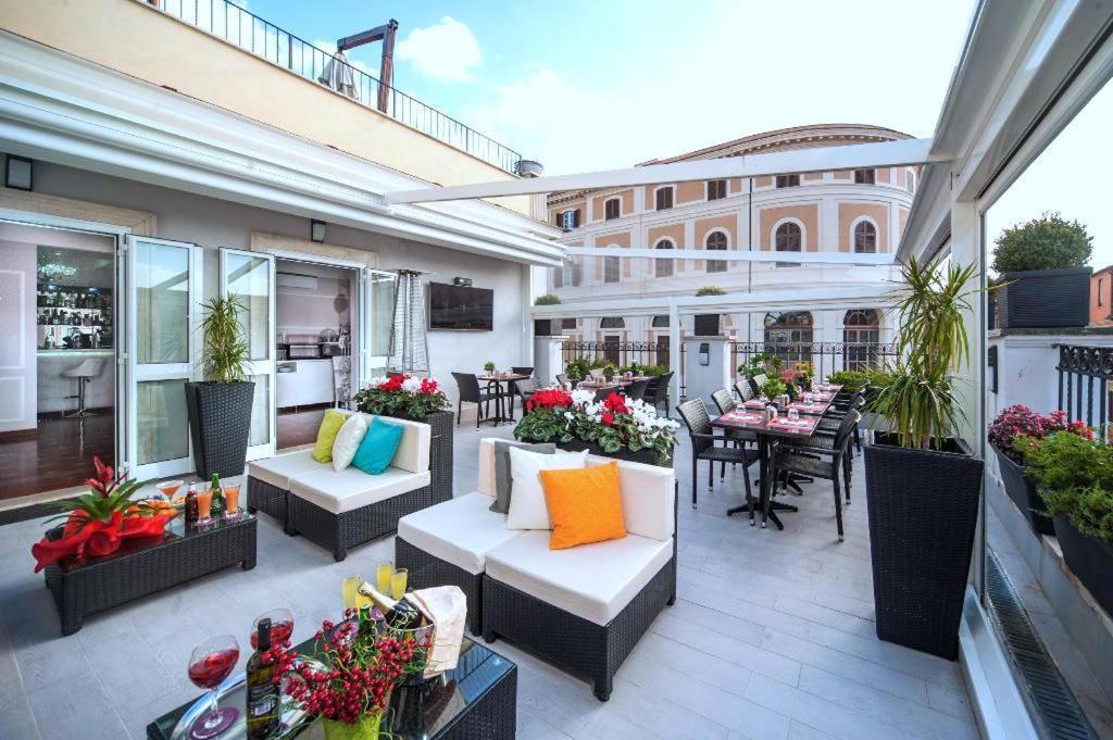 an outdoor patio with couches and tables and a building at Relais Trevi 95 Boutique Hotel in Rome