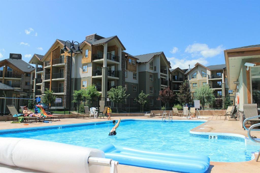 a pool at a apartment complex with a dolphin in the water at The Beach Point - Ground Floor BBQ in Invermere