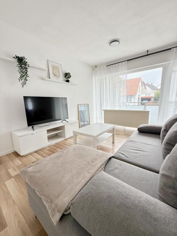 a living room with a couch and a flat screen tv at FeWo Reimer in Horn-Bad Meinberg