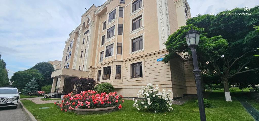 a building with flowers in front of a street light at Corps Rose Velley in Almaty