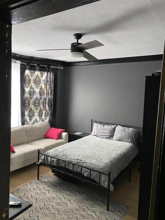 a bedroom with a ceiling fan and a bed and a couch at Blue House in Halifax