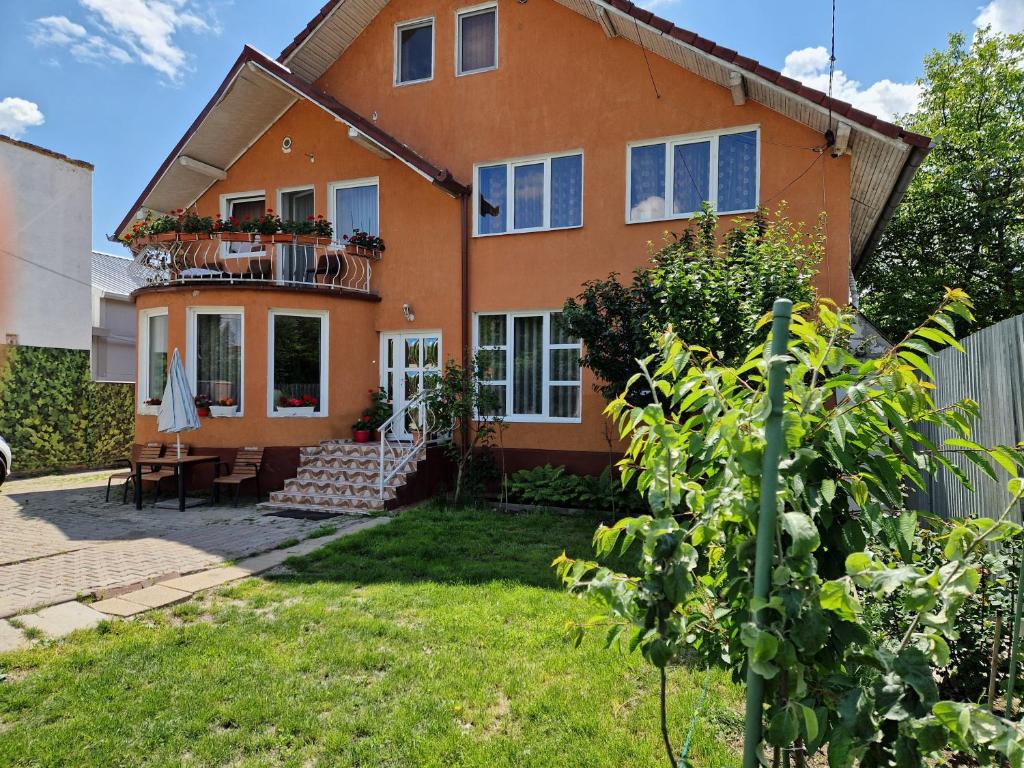 an orange house with a balcony and a yard at apartament maia 2 in Turda