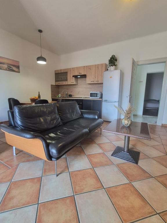 a living room with a leather couch and a table at Apartment Vužar in Opatija
