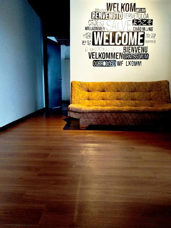 a yellow couch in a room with a wall with words at Apartaestudio confortable 1 en Combia in Pereira
