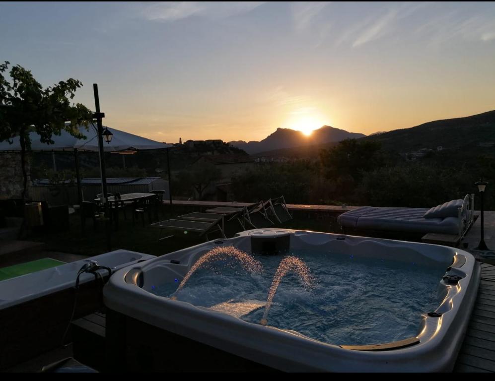 a jacuzzi tub with two fires in it with the sunset at La Terrazza di Laurino in Laurino