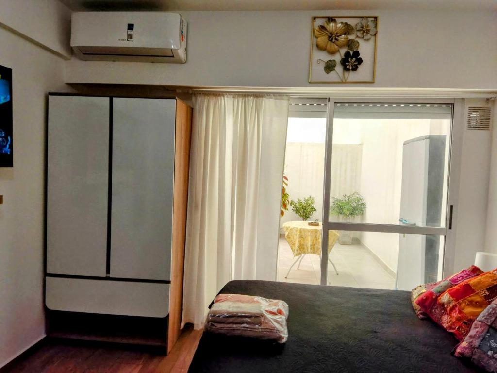 a bedroom with a large bed and a balcony at Diseñado para vos, a pasos de Bv Oroño con cochera opcional in Rosario