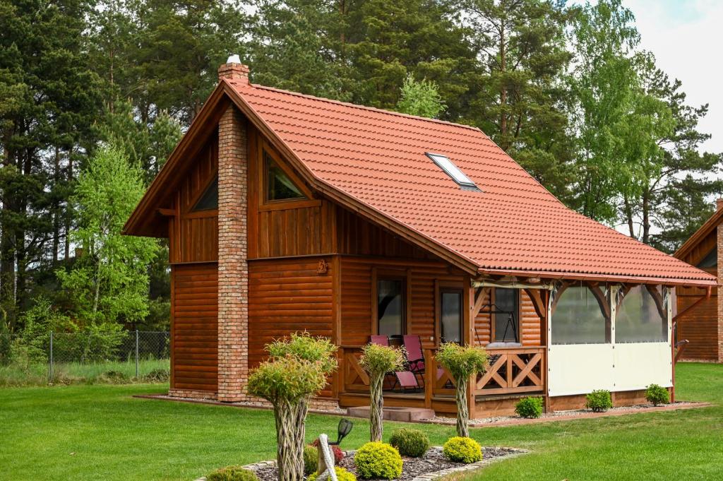 a small wooden cabin with a red roof at Domki u danusi in Stężyca