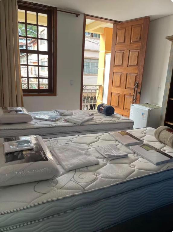 two beds in a room with a door at Pousada Solar Central in Prados