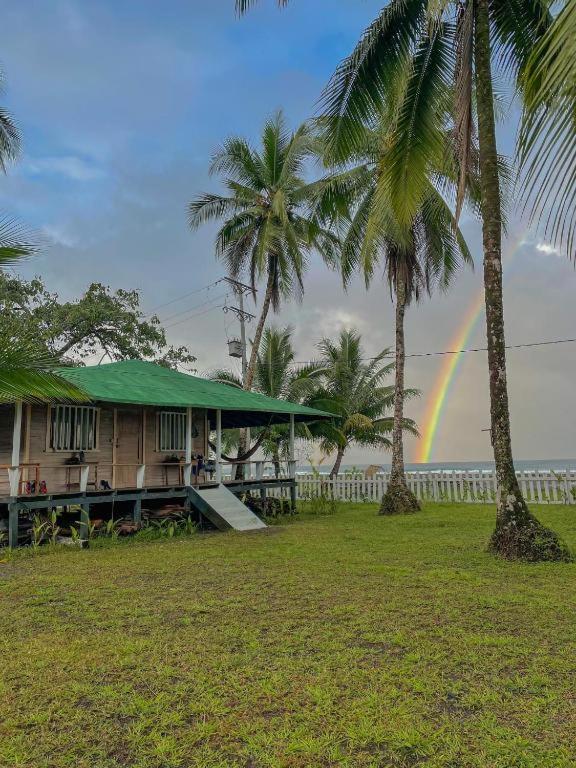 a rainbow in front of a house with palm trees at Posada Don Aí in El Valle