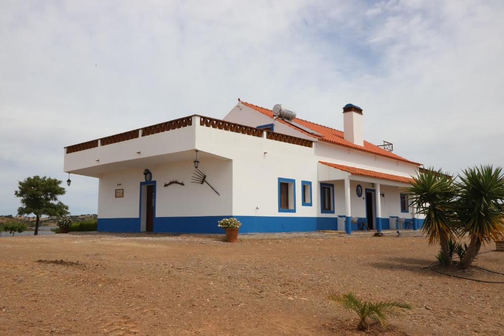 a white and blue building with a palm tree at Monte Dos Avós in Mourão