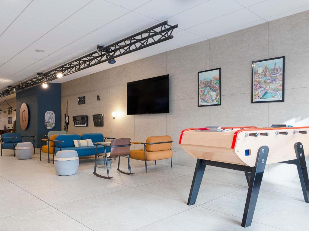 a room with a pool table and a flat screen tv at ibis Styles Nancy Centre Gare in Nancy