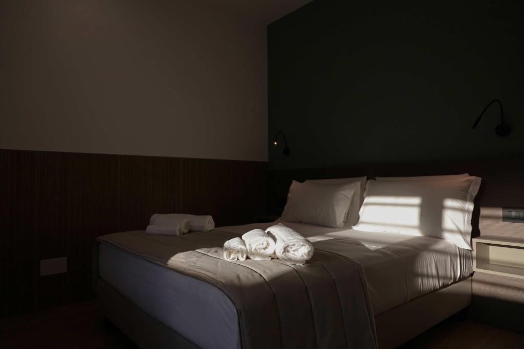 a white dog laying on a bed in a bedroom at Le Cantine Rooms & Luxury Space in San Mango Piemonte