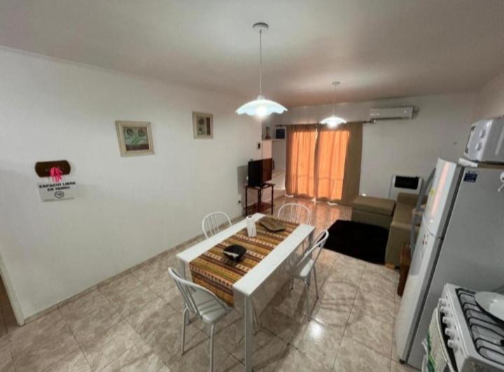 a living room with a table and chairs and a kitchen at Departamentos en Chivilcoy in Chivilcoy