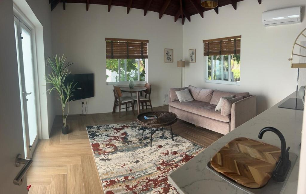 a living room with a couch and a table at The Cottage in Saint Georgeʼs
