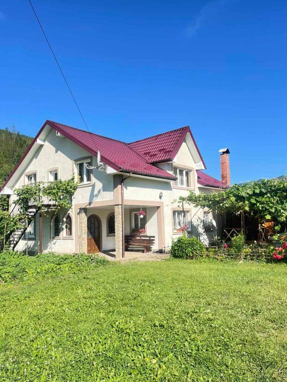 a large white house with a red roof at Світанок у горах in Verkhniy Yasenov