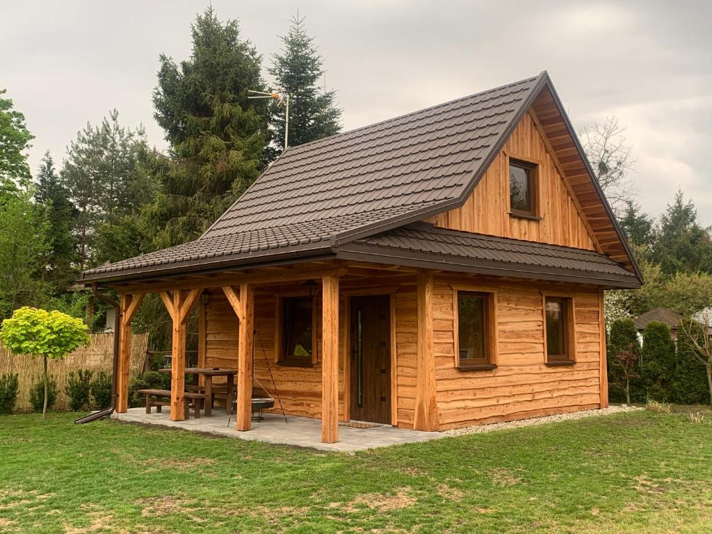 a log cabin with a gambrel roof at Domek letniskowy Remix in Zwierzyniec