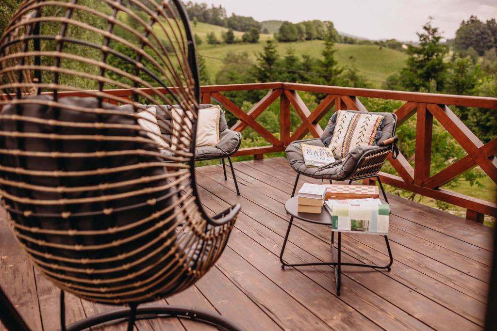 two chairs and a table on a wooden deck at Sowie Klimaty in Ludwikowice Kłodzkie