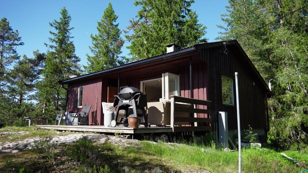 a black tiny house with a spacesuit sitting on the porch at HagestadHytteutleie Wallhall in Birkenes