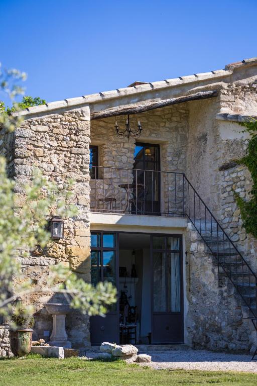 an external view of a stone house with a staircase at Maison Roque in Sannes