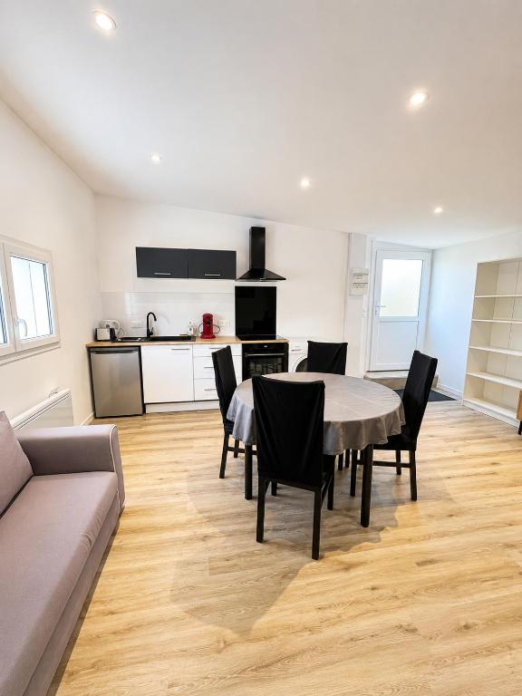 a living room with a table and chairs and a kitchen at Chez Julia in Brech