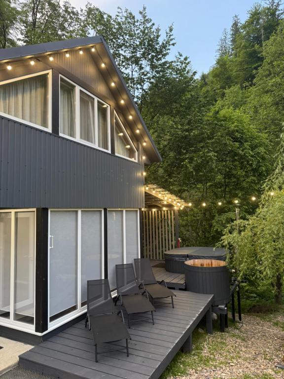 a house with a deck with chairs and lights at Гори і тиша gory & tysha in Yavoriv
