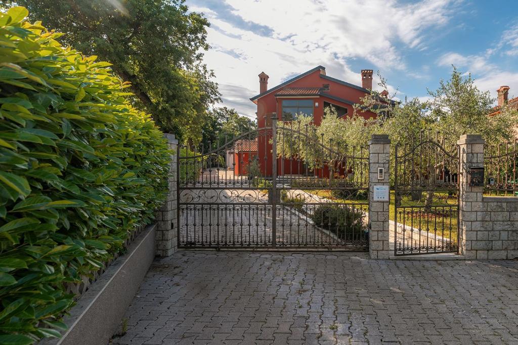 a gate to a house with a red house at Apartman Noemi in Kukci
