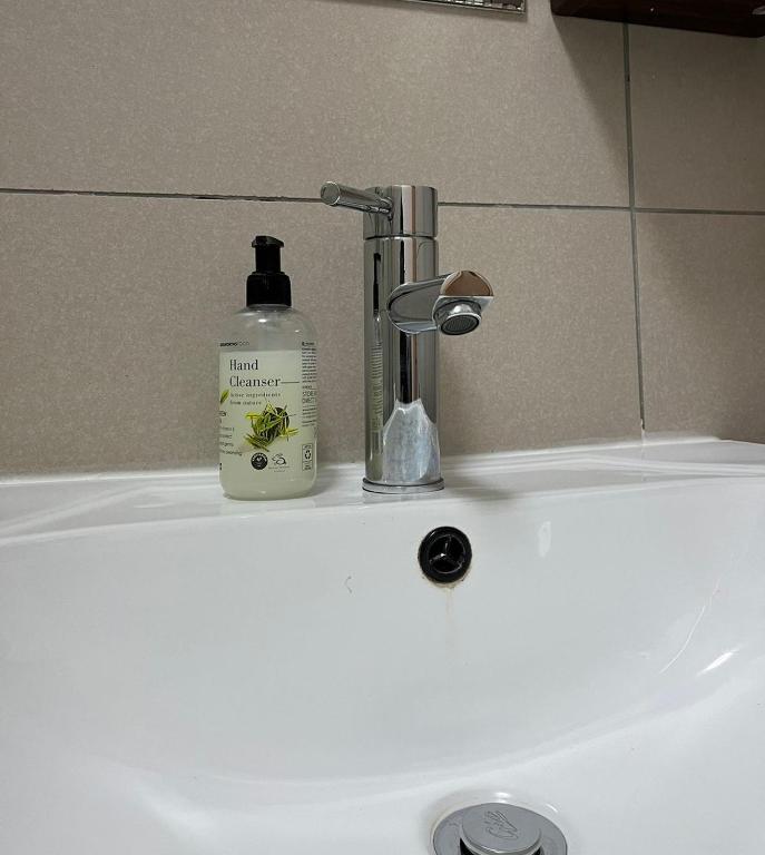 a bottle of soap sitting on top of a sink at Dainfern Cozy Loft in Fourways