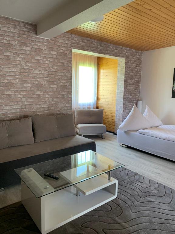 a living room with a couch and a glass coffee table at Appartment im Schwarzwald in Furtwangen