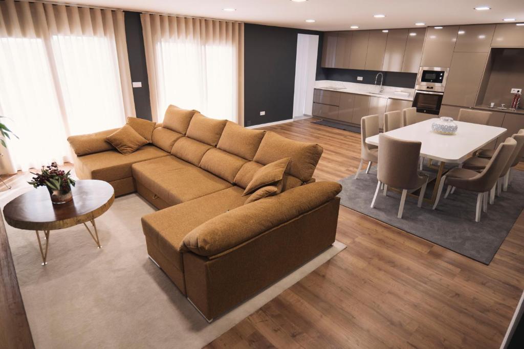 a living room with a couch and a table and a kitchen at Royal Galla Apartment in Macedo de Cavaleiros