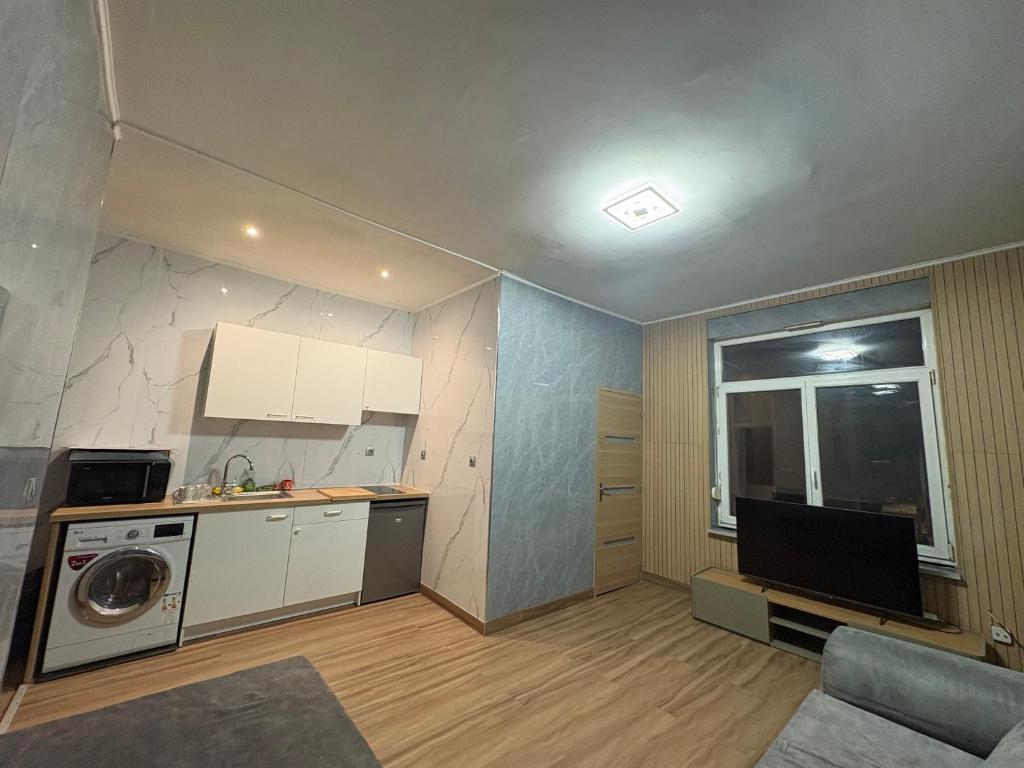 a small kitchen with a washing machine and a window at Appart 4 personnes in Lille