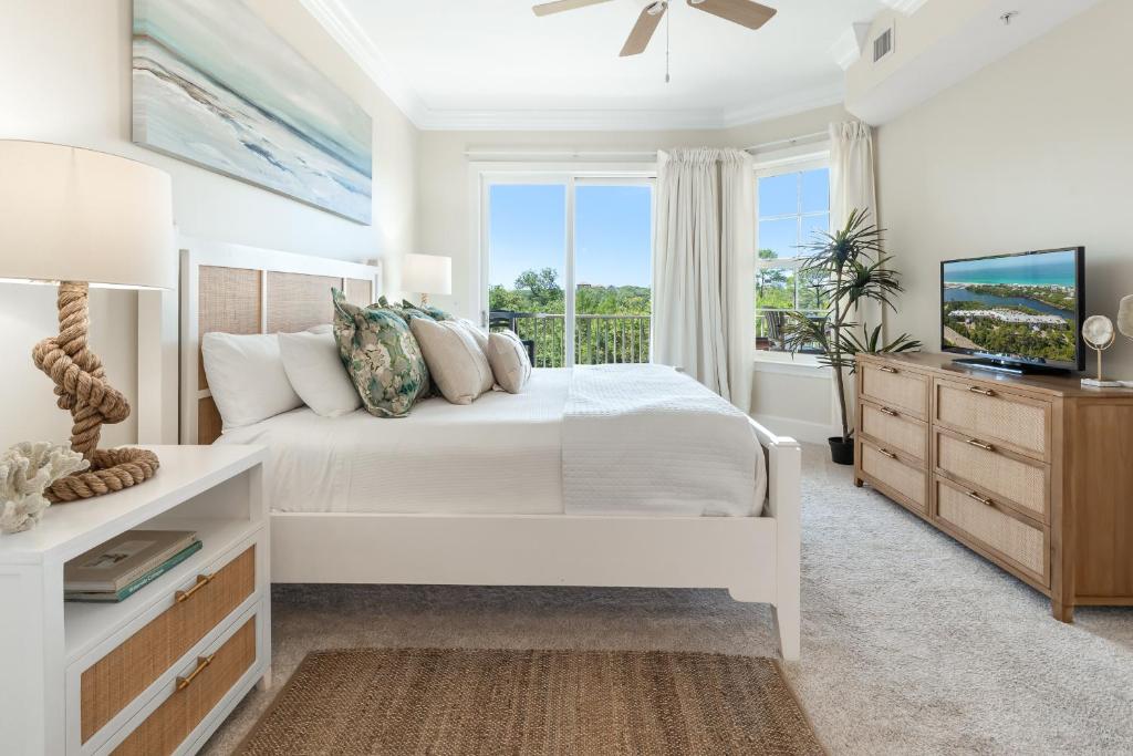 a white bedroom with a bed and a window at Sanctuary at Redfish 2104 by Newman-Dailey in Santa Rosa Beach