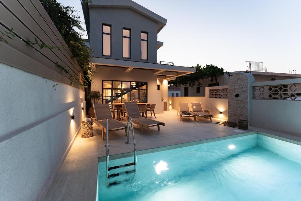 a house with a swimming pool in front of a house at Capo Davia seaside Villa in Argassi