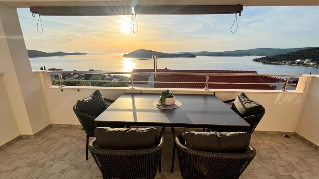 a table and chairs on a balcony with a view of the water at Apartment Stella in Ražanj