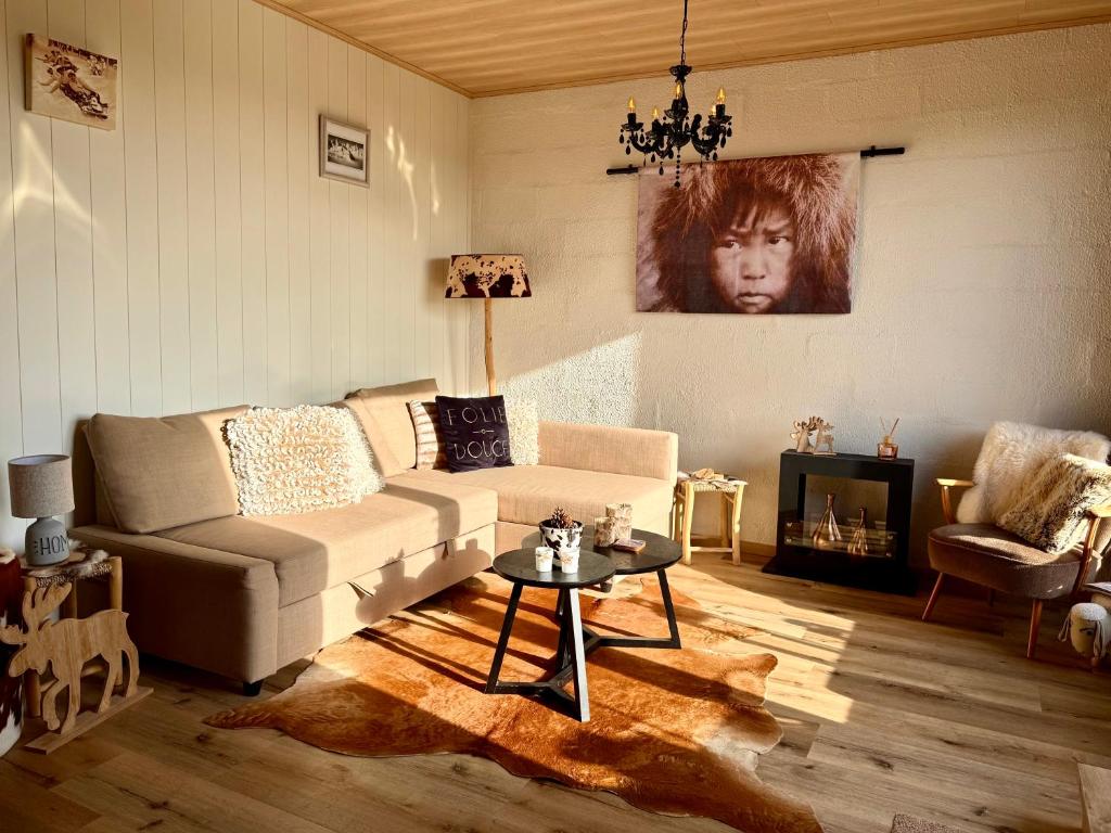 a living room with a couch and a table at Cabane La Folie Douce in Hotton