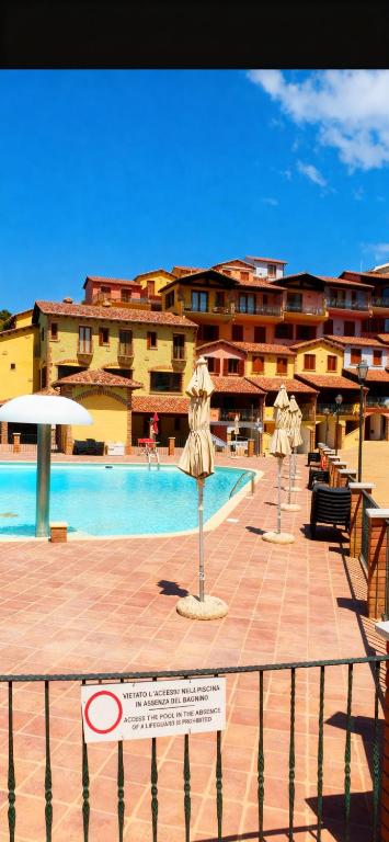 a swimming pool with a sign in front of a building at La Rosa dei venti in Nebida